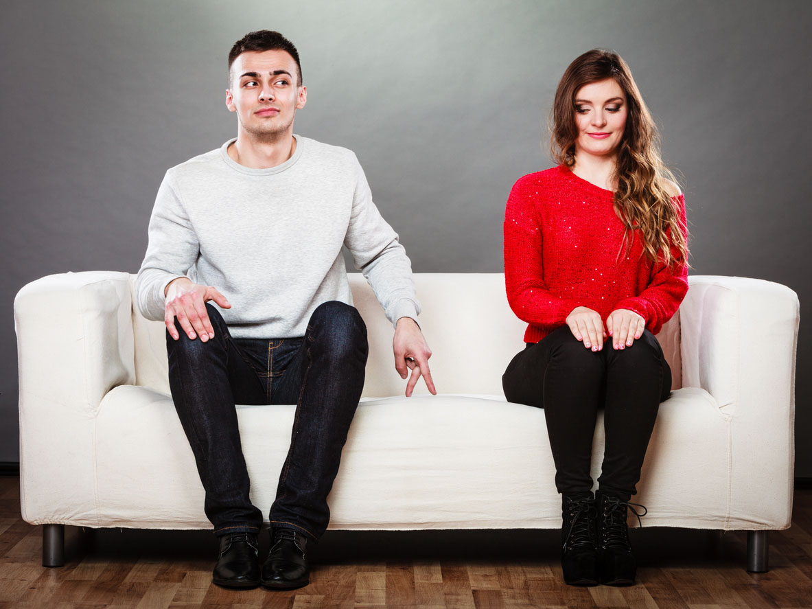 Schüchterne Frau und Mann sitzen auf dem Sofa erste Nachrichten